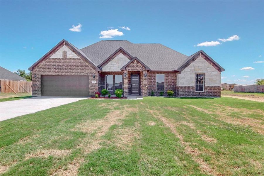 View of front of home featuring a front yard and a garage