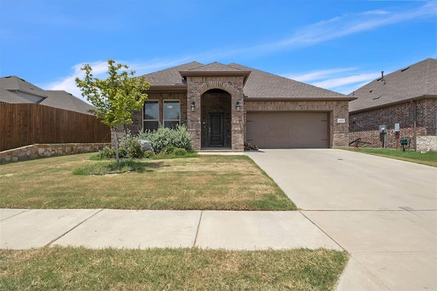 View of front of home with a garage and a front yard