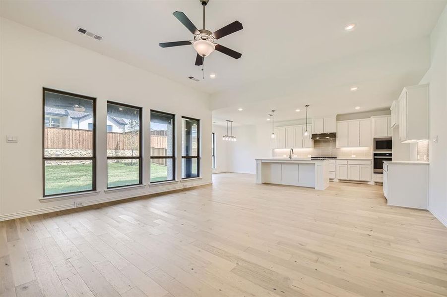 Unfurnished living room with light hardwood / wood-style floors, sink, and ceiling fan