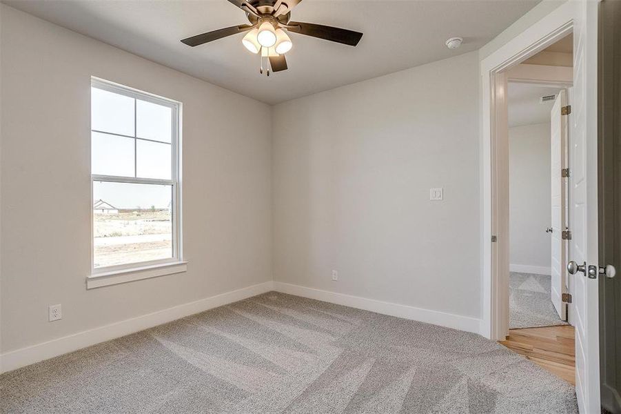 Carpeted spare room featuring ceiling fan