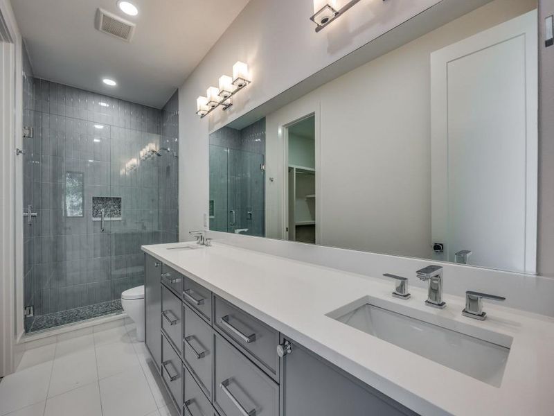 Bathroom with an enclosed shower, tile patterned floors, toilet, and vanity