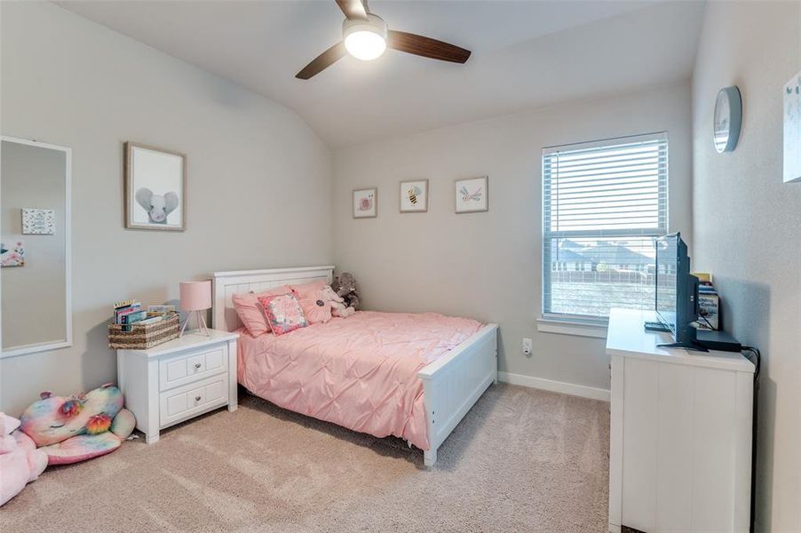 Carpeted bedroom with vaulted ceiling and ceiling fan