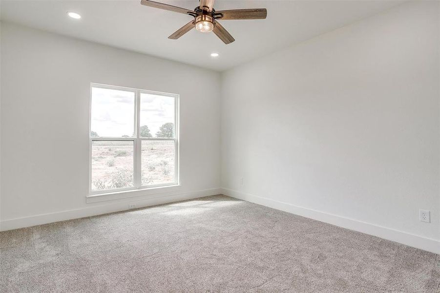 Carpeted spare room with ceiling fan