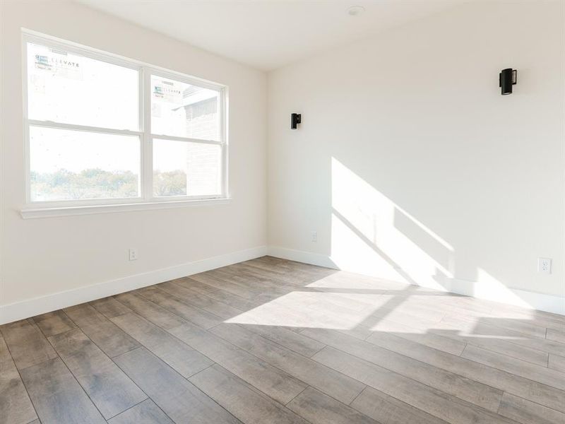 Unfurnished room with light wood-type flooring and a wealth of natural light