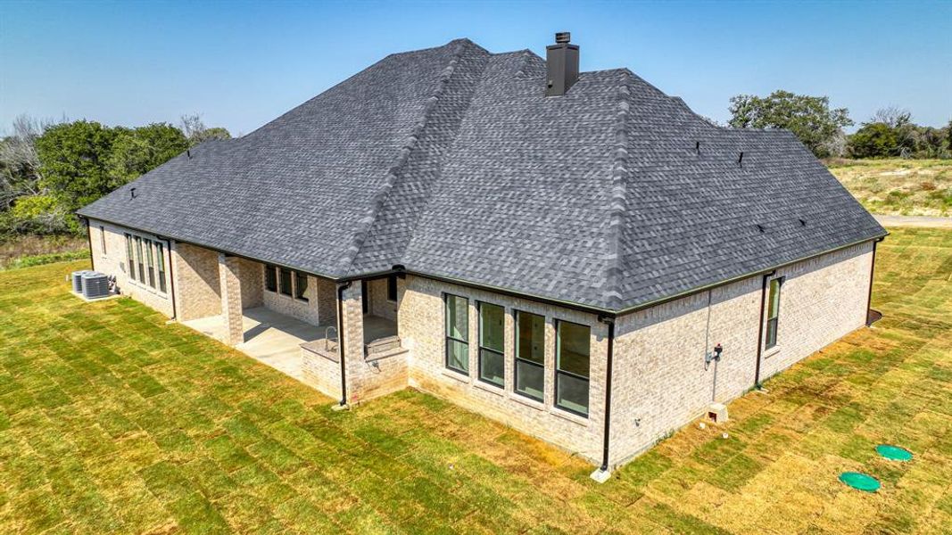 Back of property featuring a yard, a patio, and central AC