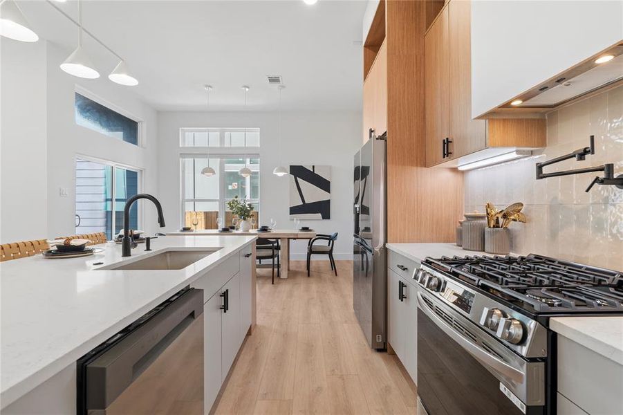 This kitchen combines elegance and practicality, with an inviting island perfect for gathering. Thoughtful details like a convenient pot filler and modern matte black fixtures elevate the space, while the open design keeps everything connected to the dining area.