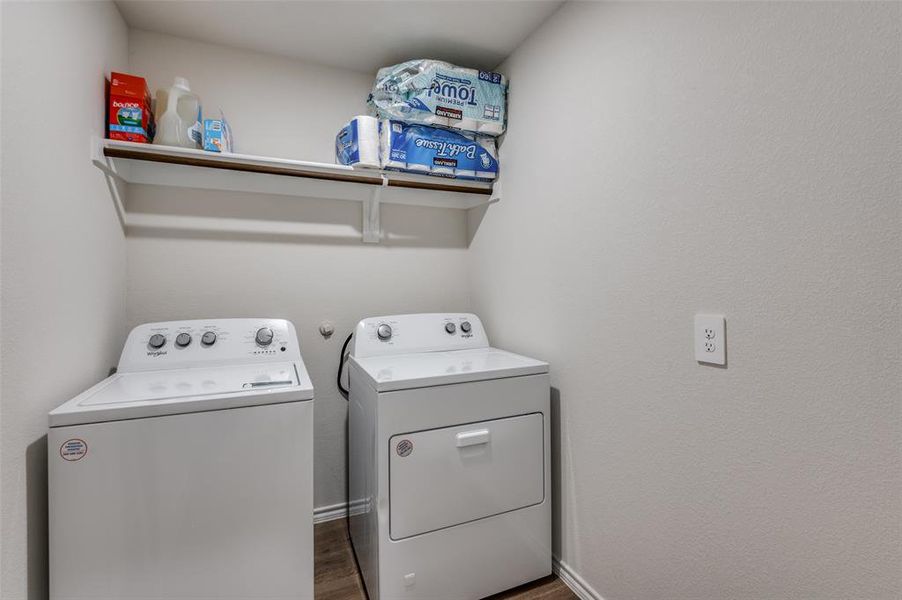 Laundry room with dark hardwood / wood-style floors and washing machine and dryer