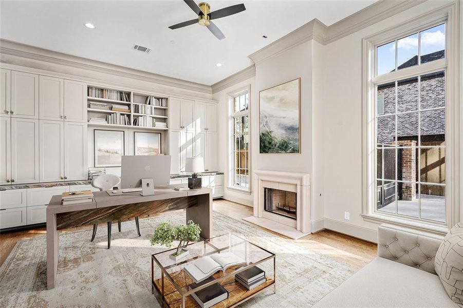 Off the entry, the large study provides the ideal work-from-home setting with built-in cabinetry and desk space topped with leather quartzite. A ceiling fan and a warm fireplace flanked by oversized windows create a relaxing ambiance.