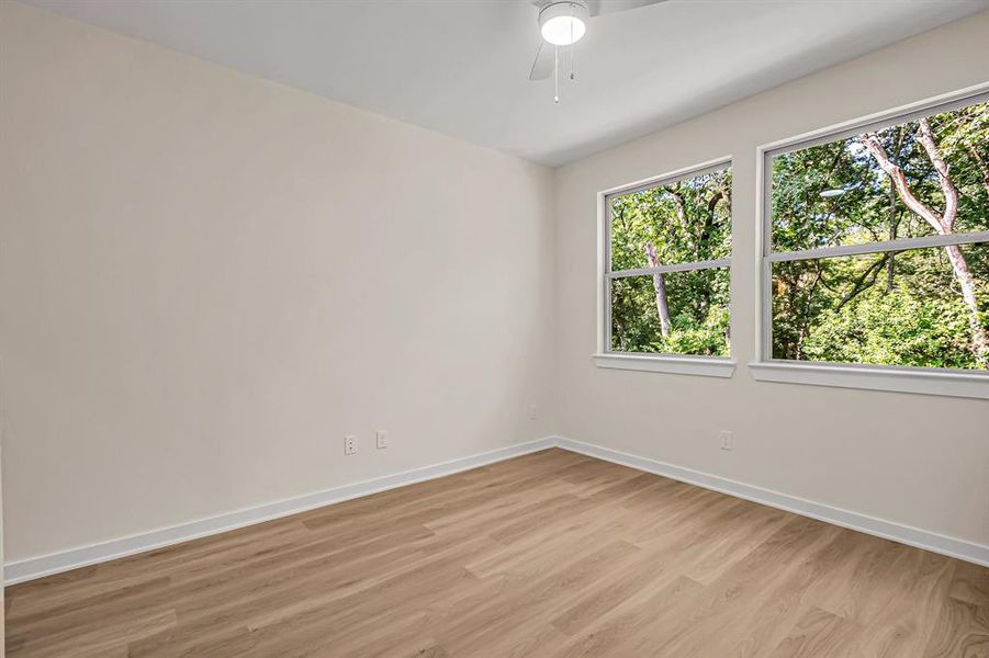 A second guest bedroom is filled with light form the large windows and overlooks the back yard as well.