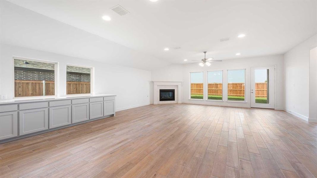 Unfurnished living room with light wood-type flooring and ceiling fan