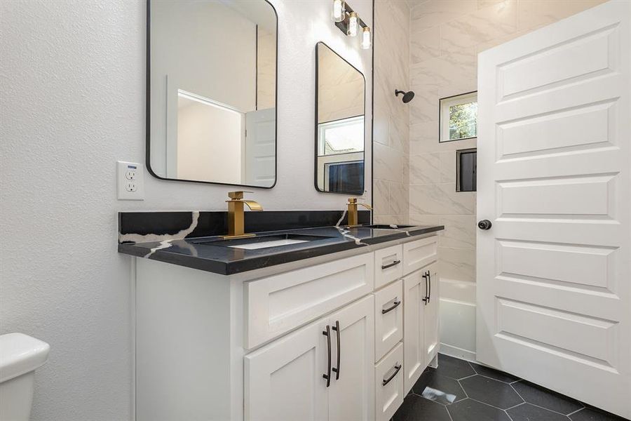 Full bathroom featuring tub / shower combination, vanity, and toilet