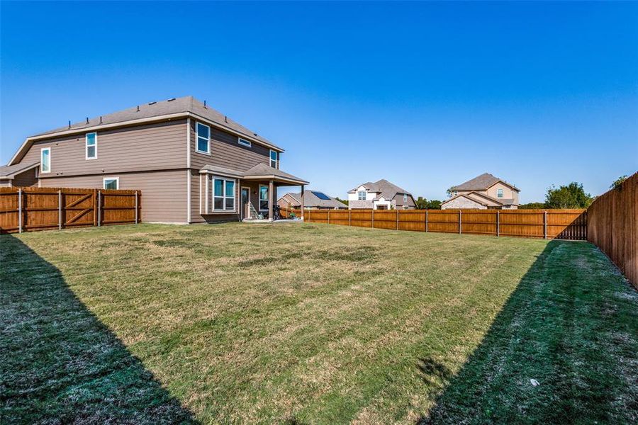 Rear view of property with a yard