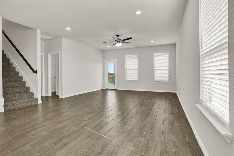 Unfurnished living room with ceiling fan and hardwood / wood-style flooring