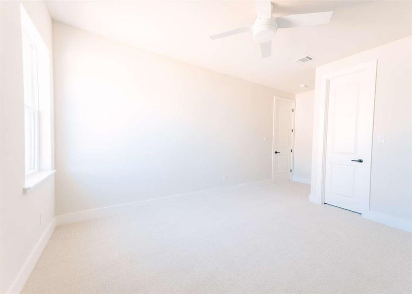 Spare room with light carpet and ceiling fan