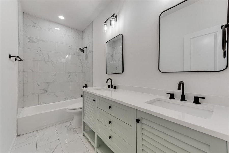 Full bathroom with vanity, toilet, and tiled shower / bath