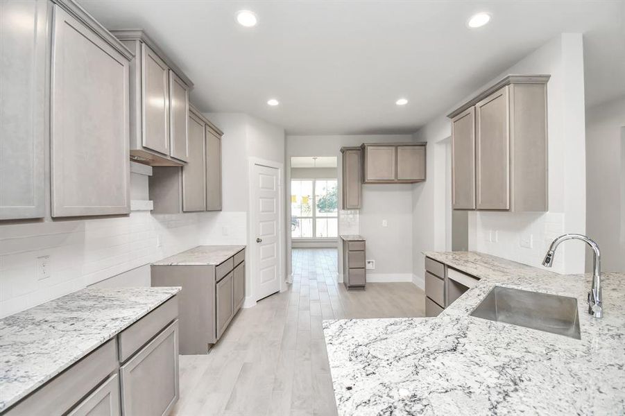 Discover another perspective of this stunning kitchen, generously appointed with an abundance of counter space.