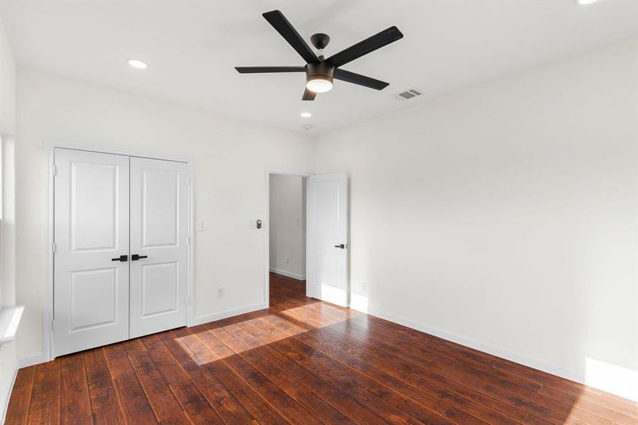 Unfurnished bedroom featuring ceiling fan, hardwood / wood-style flooring, and a closet