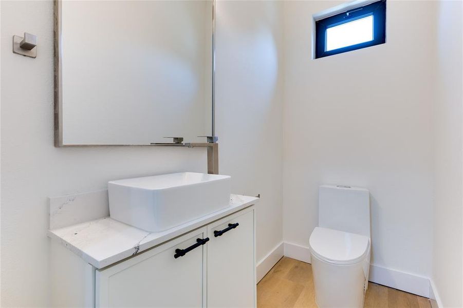 Bathroom with hardwood / wood-style floors, vanity, and toilet