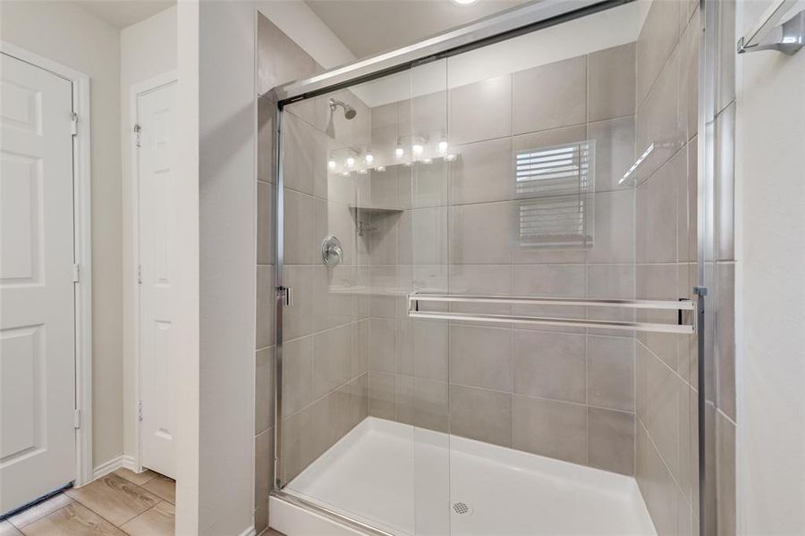 Bathroom with LVP floors and a shower with door