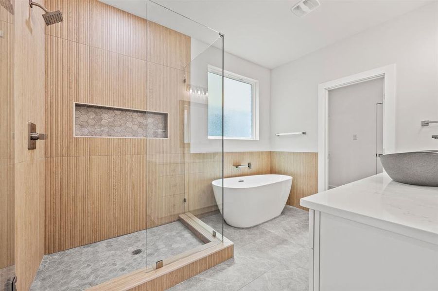 Bathroom featuring tile walls, shower with separate bathtub, tile patterned floors, and vanity