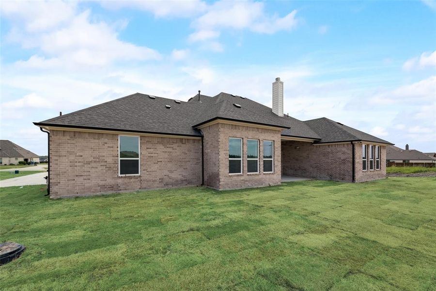 Rear view of house featuring a lawn