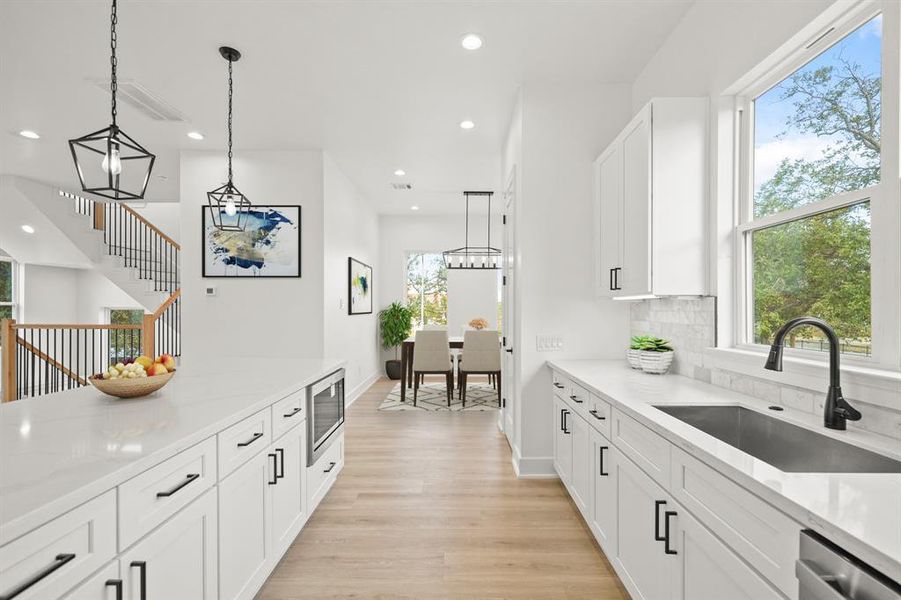 Virtually Staged: This kitchen includes under cabinet lighting and outlets, and luxury vinyl plank floors.