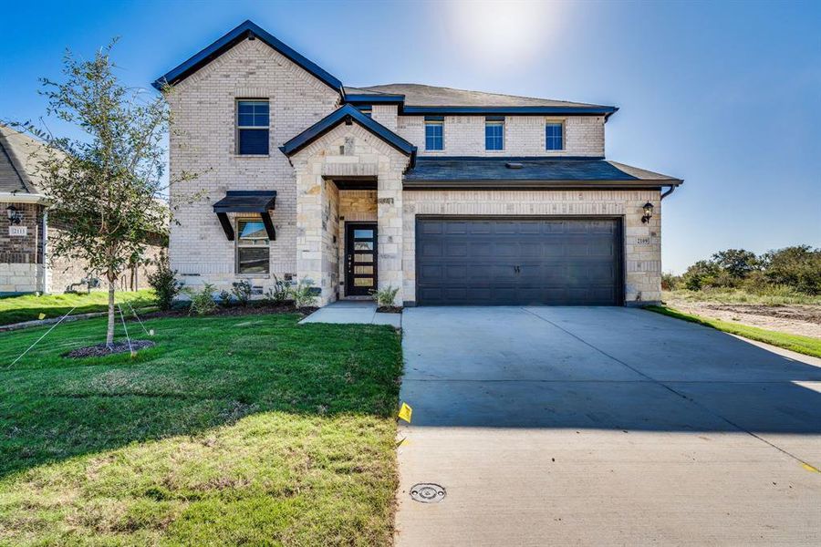 View of front of house featuring a front yard and a garage