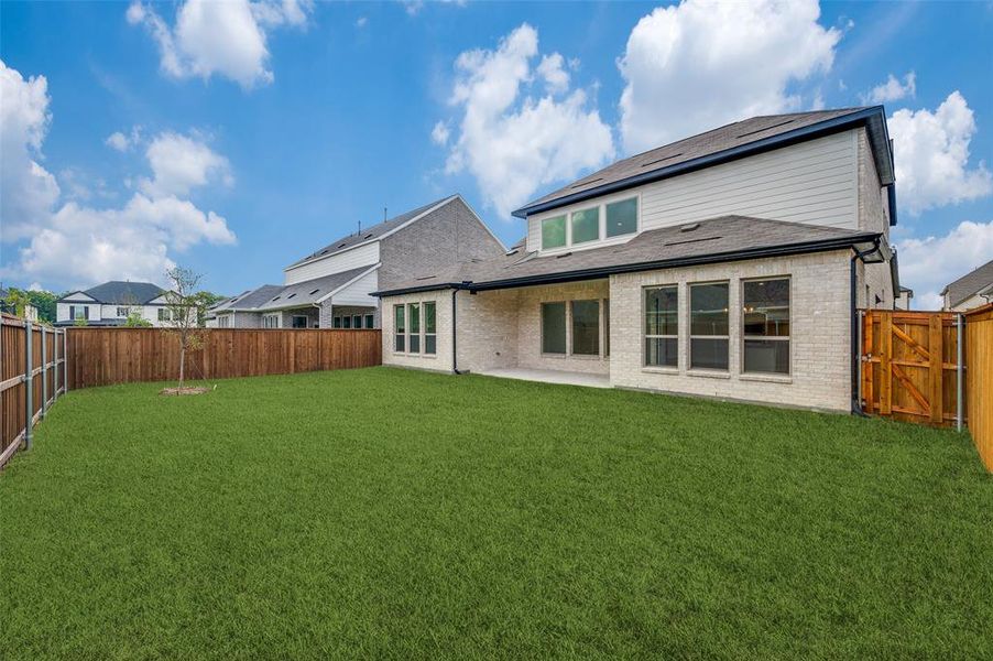 Back of property featuring a patio area and a lawn