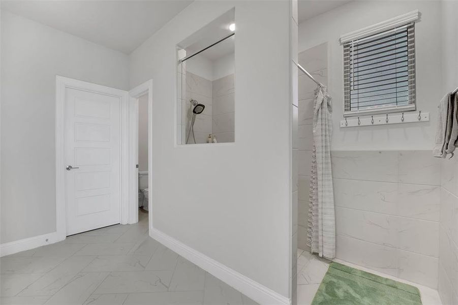 Bathroom featuring toilet and a shower with shower curtain