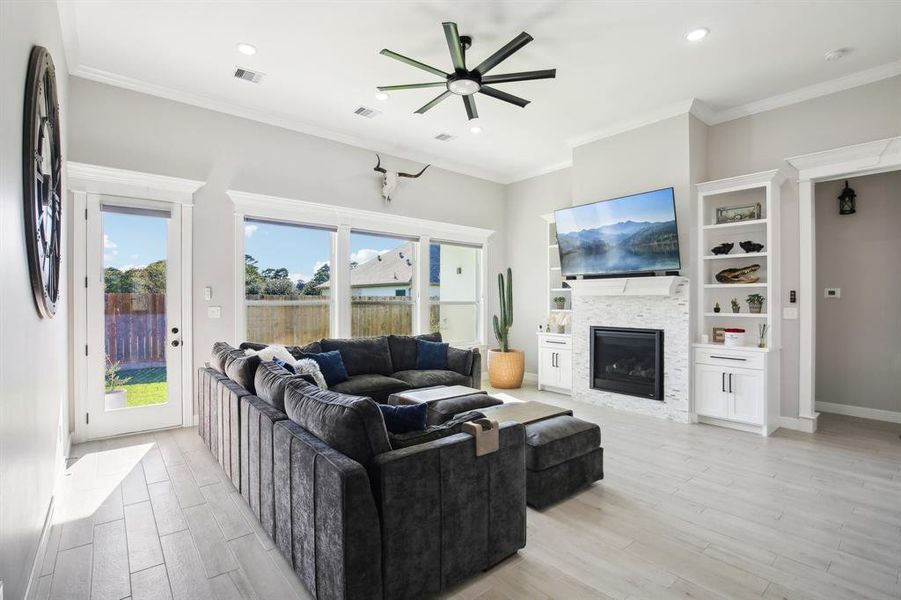 Open living space with custom window coverings, built-ins and beautiful fireplace.