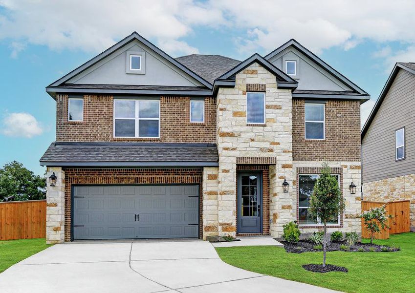 Exterior of the Sterling with beautiful landscaping, coach lights, and a two-car garage.