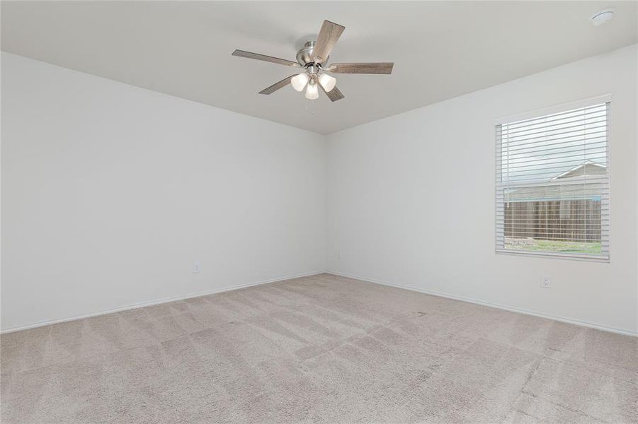 Carpeted empty room featuring ceiling fan