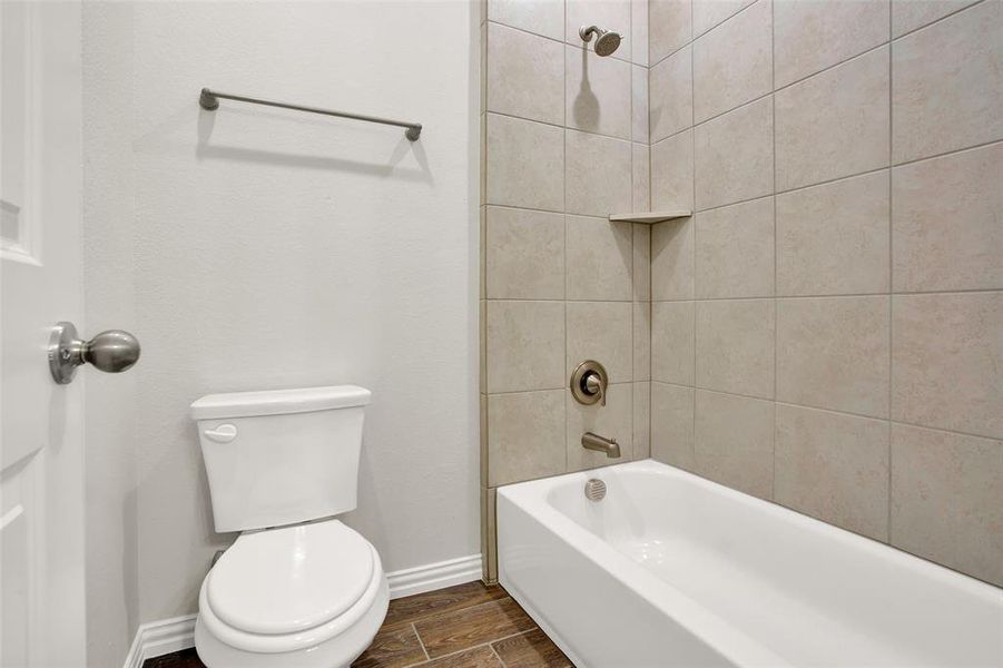 Bathroom featuring toilet and tiled shower / bath combo