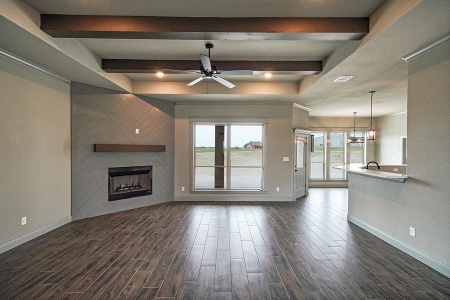 Wood accent fireplace, a healthy amount of sunlight, and dark hardwood tile flooring