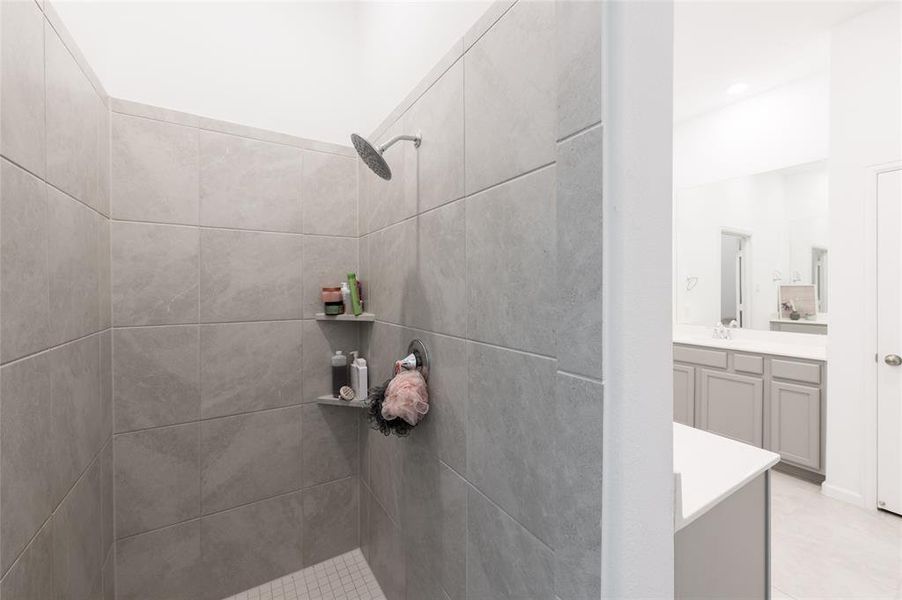 Step into serenity in this luxurious primary bathroom, boasting a modern standing shower and rainfall showerhead.
