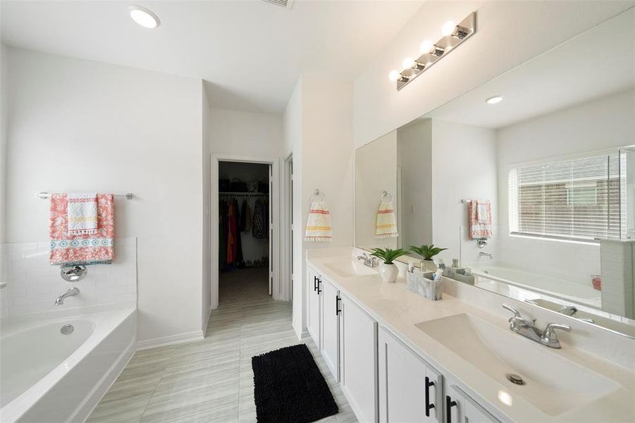 Primary bathroom with double sinks and an oversized vanity with extra cabinet space.