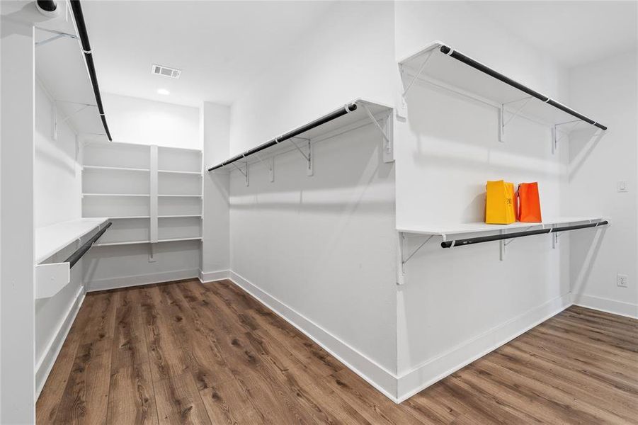 This view highlights the vastness of the primary closet, providing ample space for all your wardrobe needs