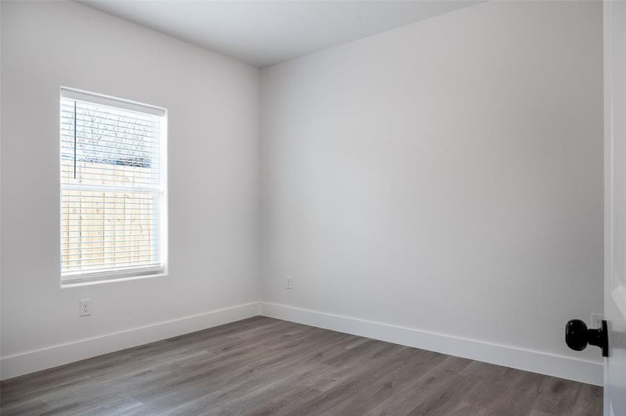 Empty room featuring a healthy amount of sunlight and hardwood / wood-style floors