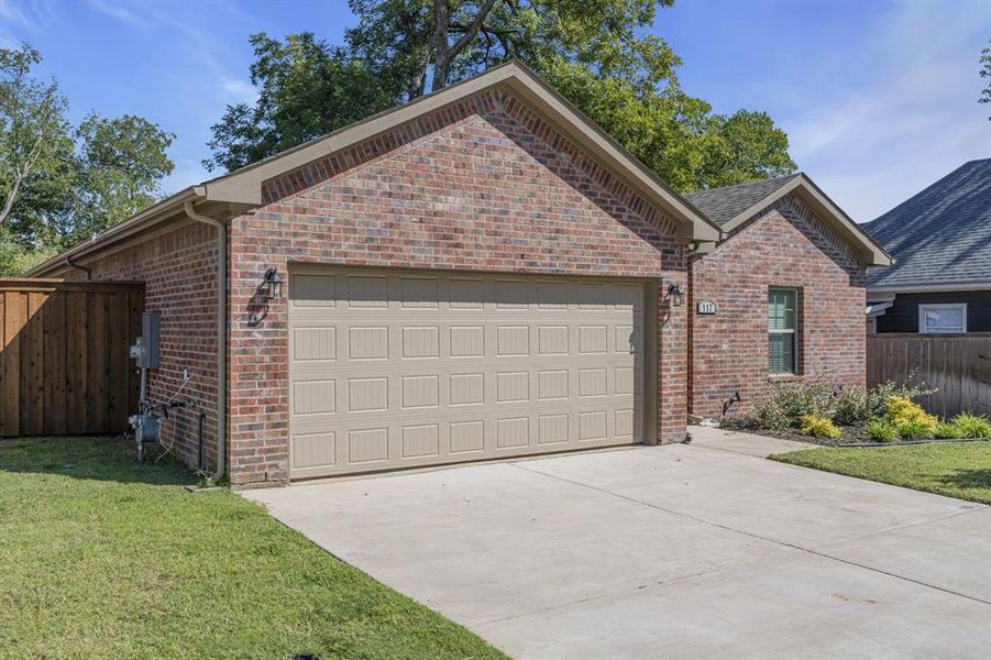 View of front of house featuring a front lawn and a garage