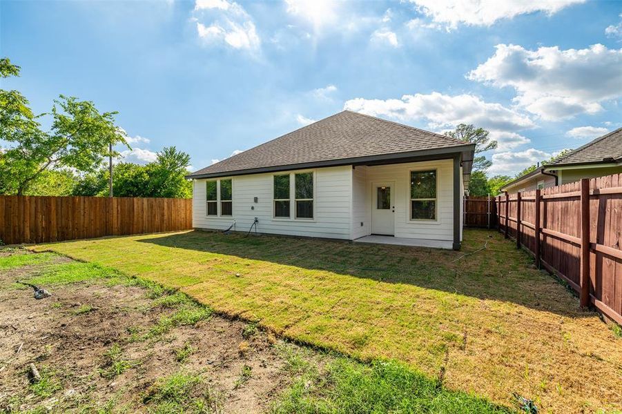 Back of property featuring a yard and a patio