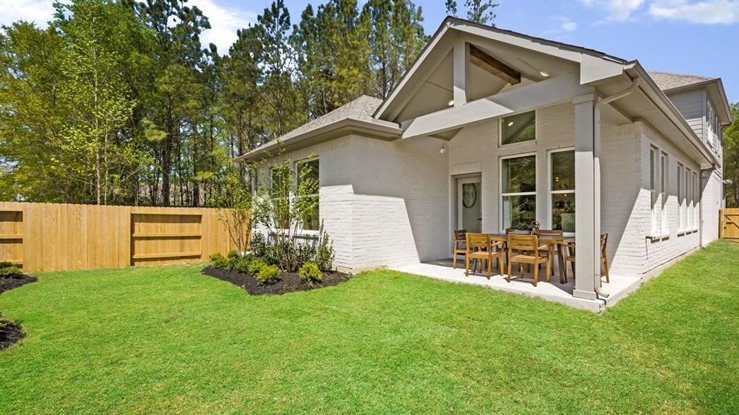 Cozy covered patio featuring stamped concrete flooring, offering a prime spot to unwind while taking in the tranquil greenspace views.