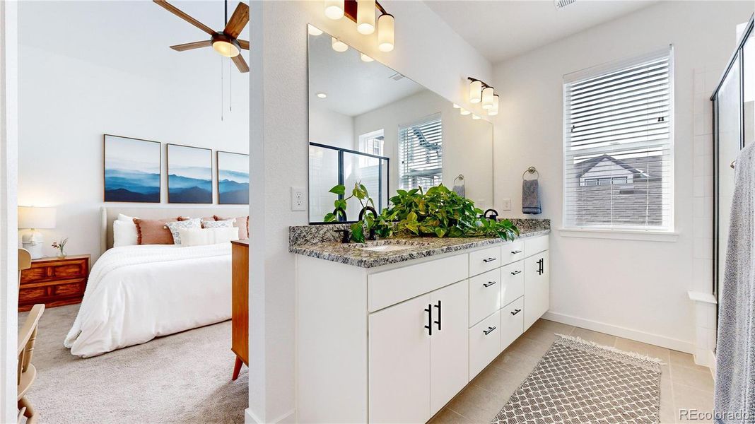 Dual sinks and walk-in tiled shower with separate water closet + linen closet.