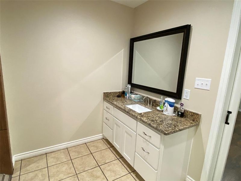 Primary Bathroom with tile flooring and vanity