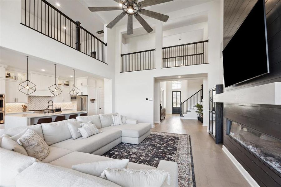 The living area opens to an elegant kitchen with a large island and pendant lighting.