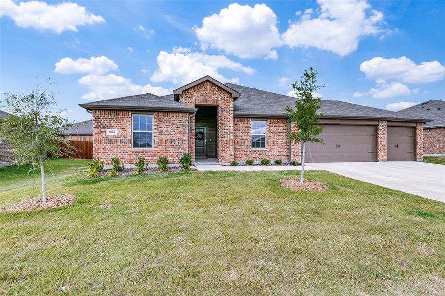 View of front of home with a garage and a front lawn