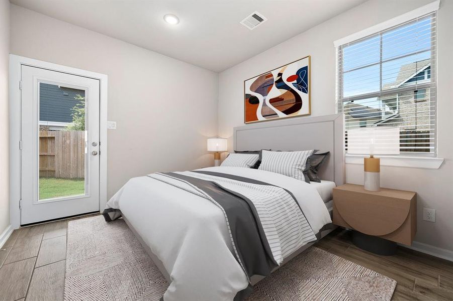 Secondary bedroom features wood flooring, neutral paint, recessed lighting, a large window with privacy blinds and access to the backyard!