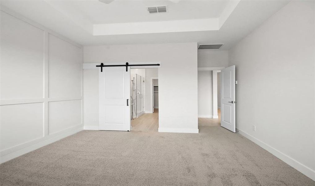 Primary suite with barn door leading to the primary bath