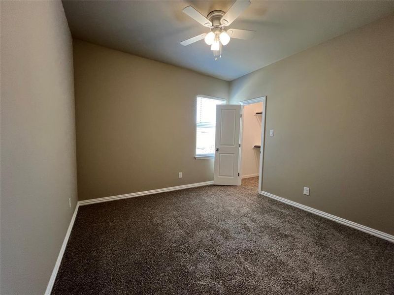 Carpeted empty room with ceiling fan