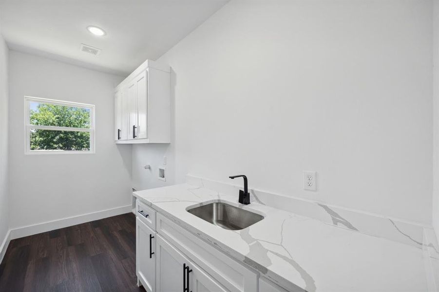 Laundry room featuring cabinets, dark hardwood / wood-style floors, hookup for a washing machine, electric dryer hookup, and sink