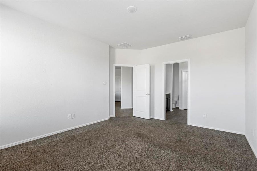 Unfurnished bedroom with dark colored carpet